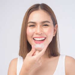 Woman about to put in Invisalign aligner