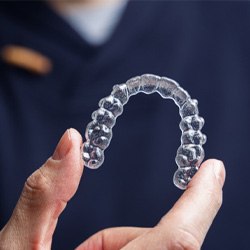 Close up of hand holding Invisalign aligner