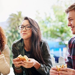 Girl with group eating a burger