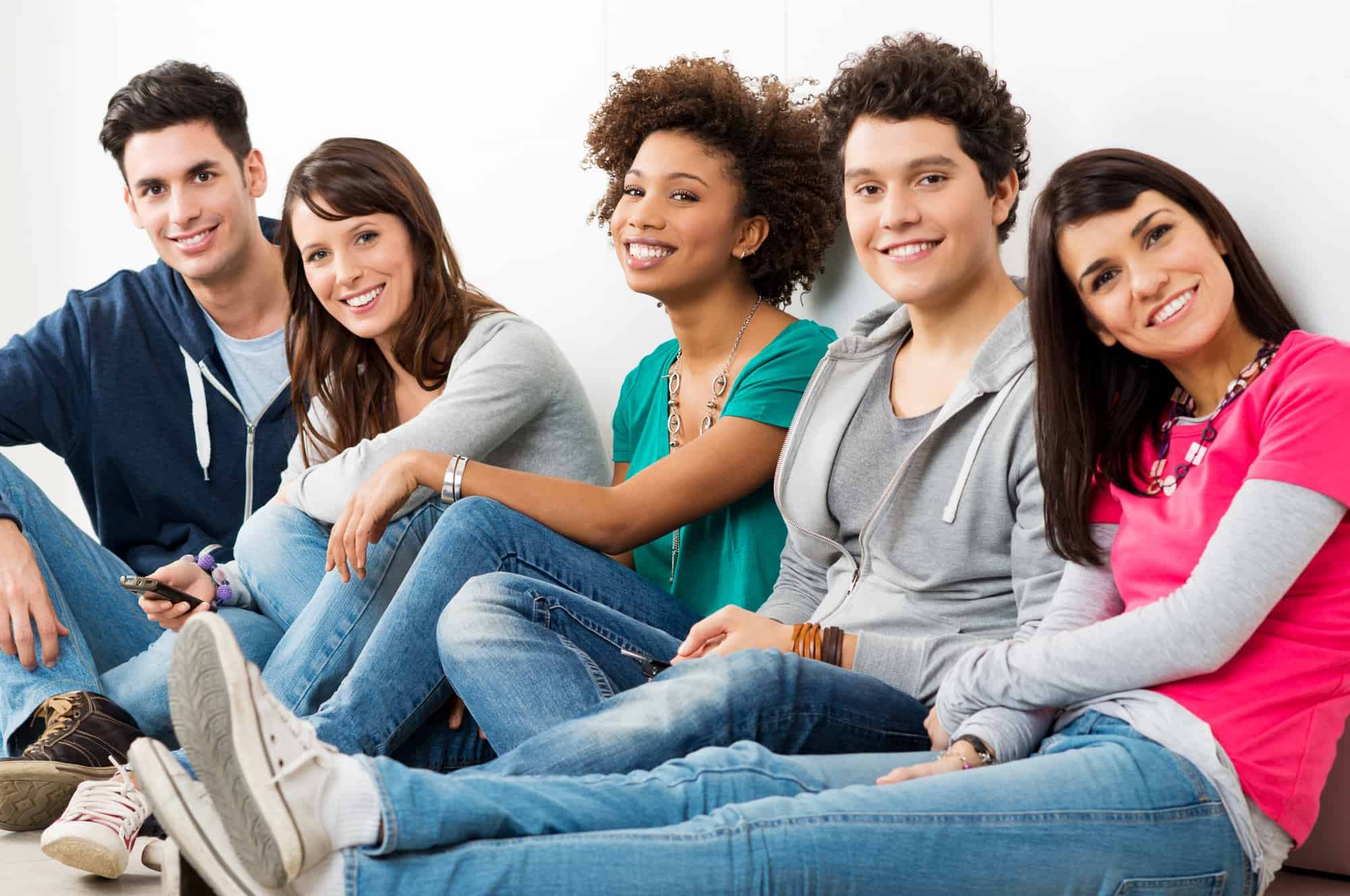 Group of smiling young people receiving Invisalign teen treatment