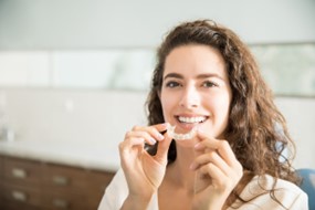 Woman holding her Invisalign aligner.