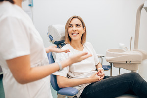 Smiling patient talking to a dentist